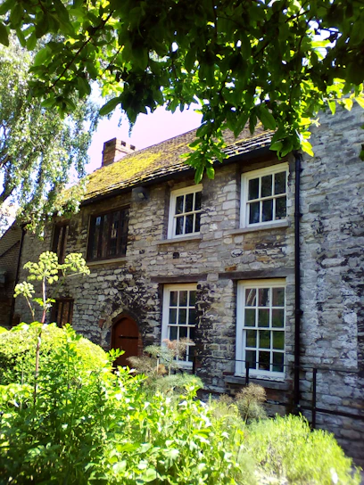 A cozy 14th-century stone cottage nestled within the medieval fort of Flaujac, bathed in soft morning light.