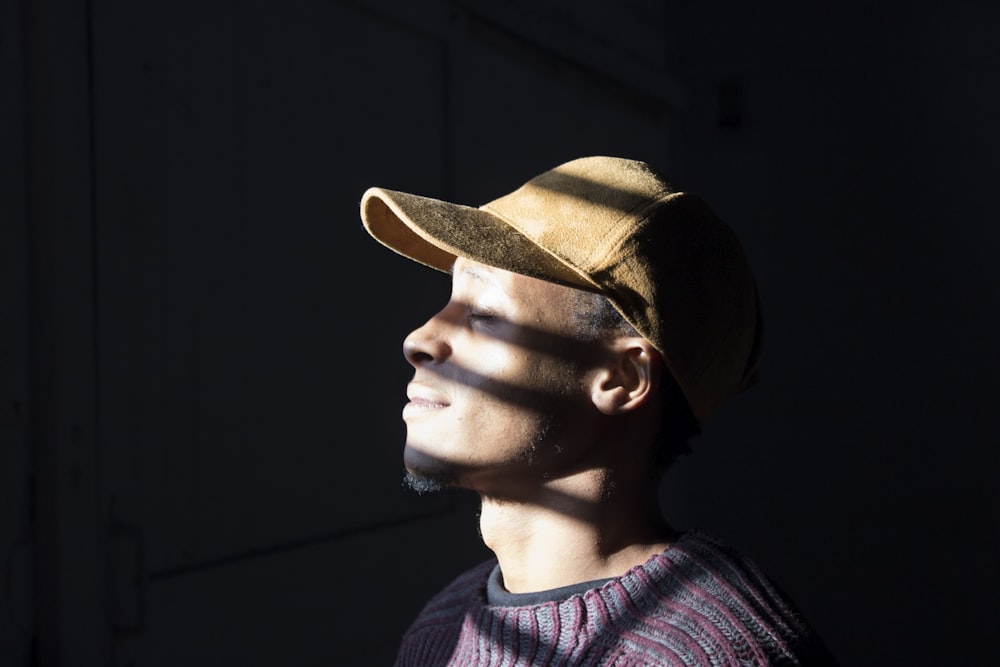 man standing wearing brown cap standing