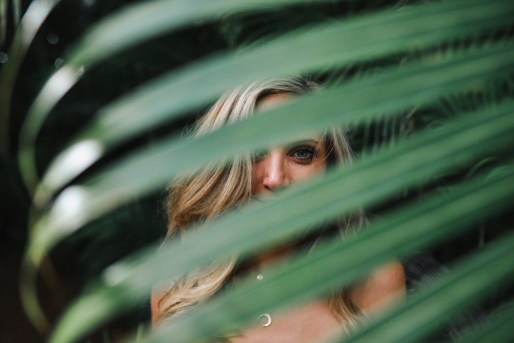 green leaf in front of smiling woman