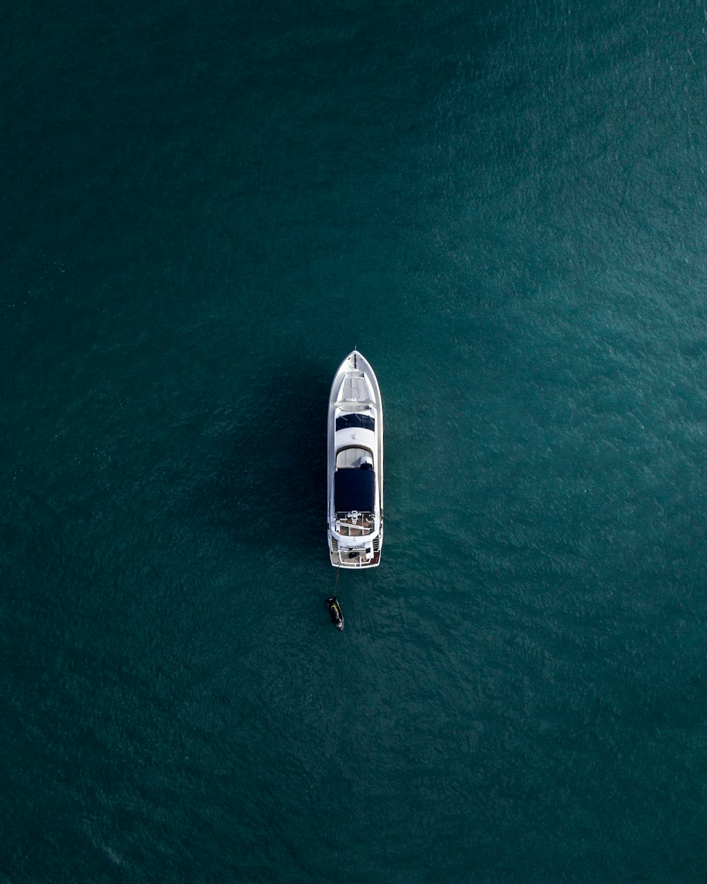 Fotografía aérea de yate blanco en aguas tranquilas.