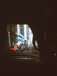 City view showing multiple cars equipped with digital advertisement tablets driving through busy streets.