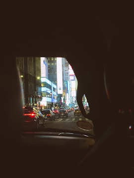 City view showing multiple cars equipped with digital advertisement tablets driving through busy streets.