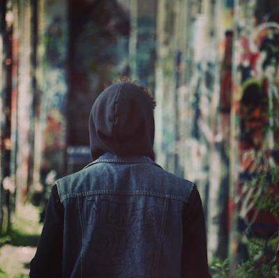 Model wearing a custom-designed streetwear hoodie in a muted palette, standing against an urban Stockholm backdrop