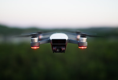 A security drone flying over a residential area at dusk, capturing surveillance footage.