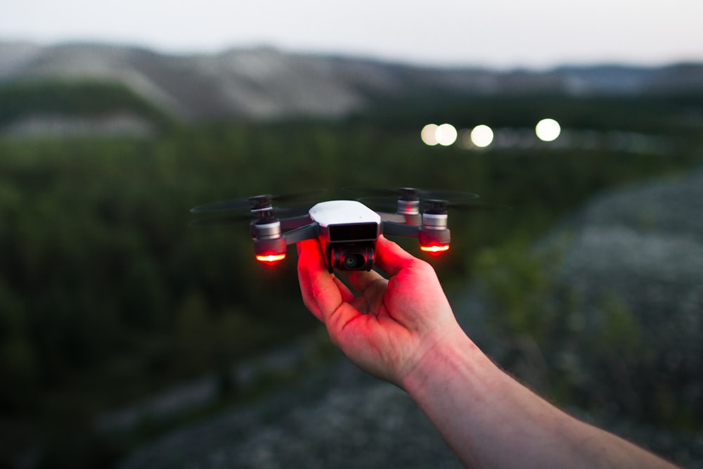 person holding black and red quadcopter