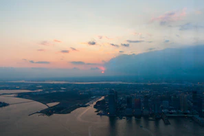 A panoramic view of Seoul's skyline at sunset with the Han River reflecting city lights