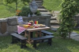 Wide shot of a picnic table with cooking equipment and party accessories arranged