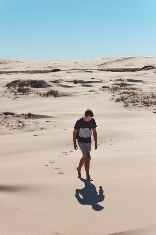 man walking on desert in Newcastle Australia