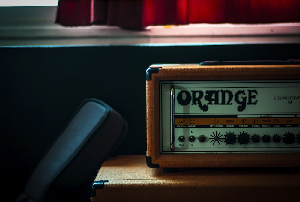 orange and gray Orange radio on brown wooden plank