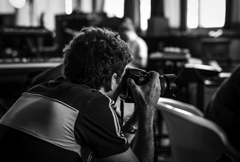 grayscale photography on man taking photos