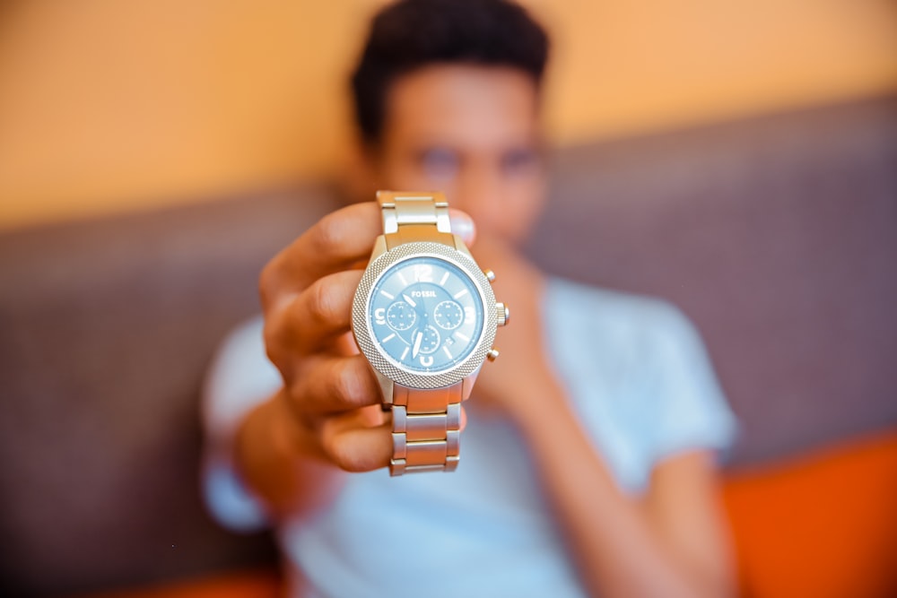 selective focus photography of man holding chronograph watch