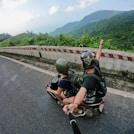 fish eye photography on woman riding motor scooter with man on bridge