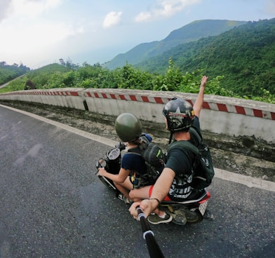 fish eye photography on woman riding motor scooter with man on bridge