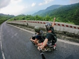 fish eye photography on woman riding motor scooter with man on bridge