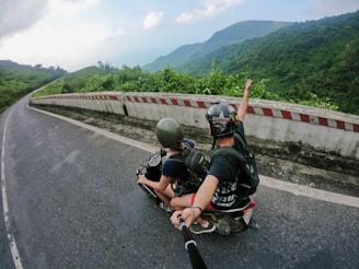 fish eye photography on woman riding motor scooter with man on bridge