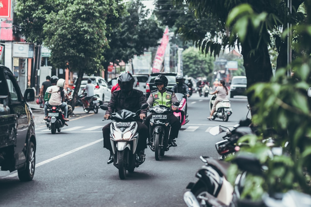 selective focus photography of people riding motorcycles on road