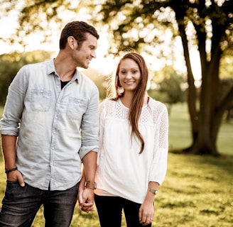 man holding hand of woman standing near tree