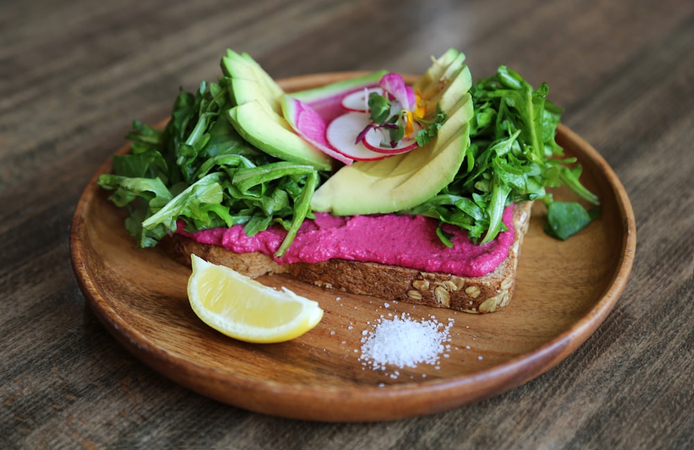 avocat, tranche de citron vert et pain sur assiette avec du sel