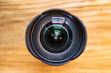 Close-up of a camera lens reflecting a bustling newsroom environment