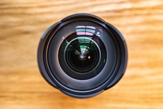 A close-up of a camera lens with reflections of nature.