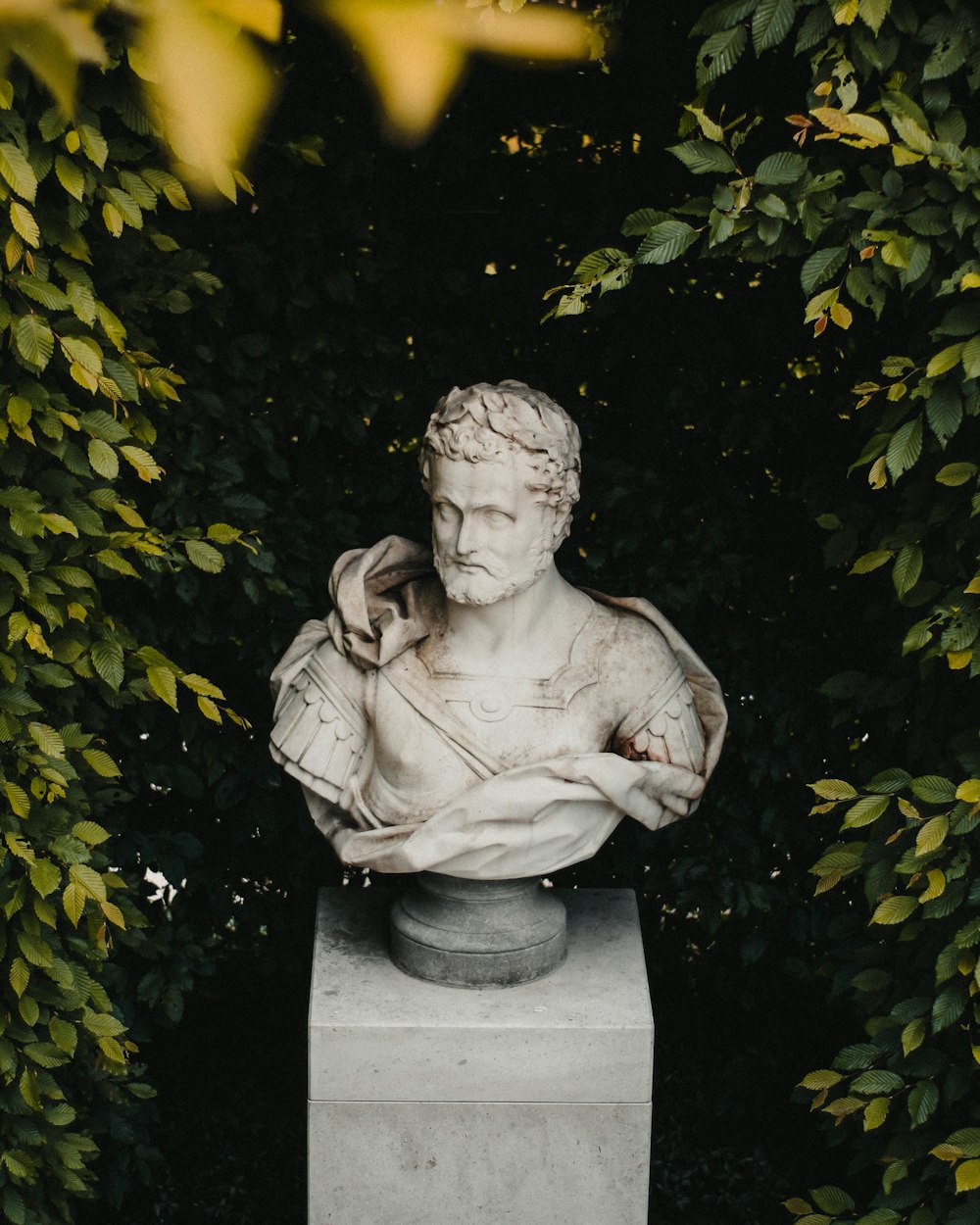 a statue of a man sitting on top of a cement block