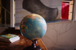 A trainer explaining concepts using a globe and books during a bespoke training workshop.