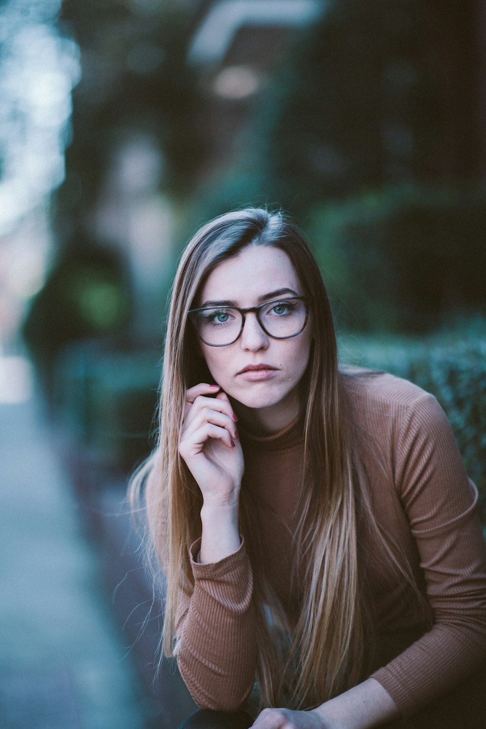 selective focus photography of woman wearing brown long-sleeved shirt and black framed eyeglasses