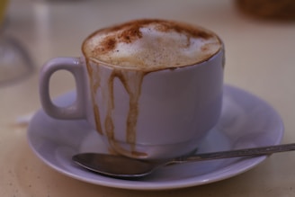 A steaming cup of rich Polish coffee served in a classic ceramic mug with a cinnamon stick on the side.