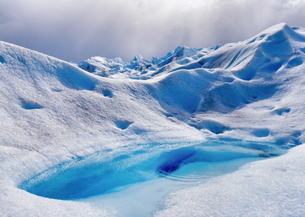 lac au milieu d’une montagne couverte de glace pendant la journée