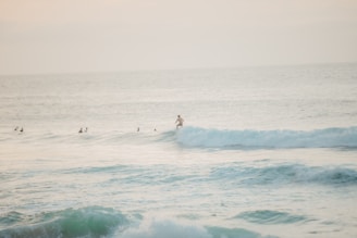 Solo surfer practicing on a gentle wave with focused instructor support.