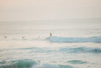 A surf instructor guiding a beginner through gentle waves at Honu beach.