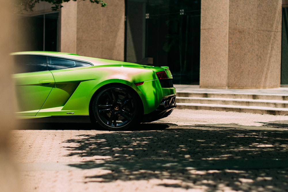 green sports coupe parked at the road near the building