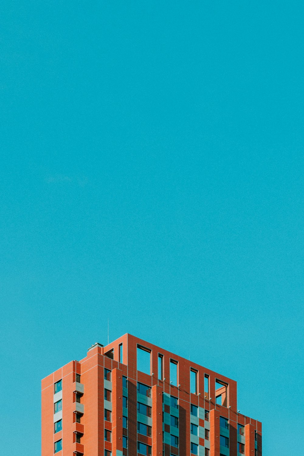 Immeuble de grande hauteur en béton brun sous un ciel bleu