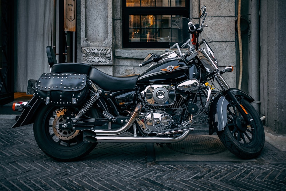 Motocicleta de turismo negra y gris estacionada cerca de la ventana