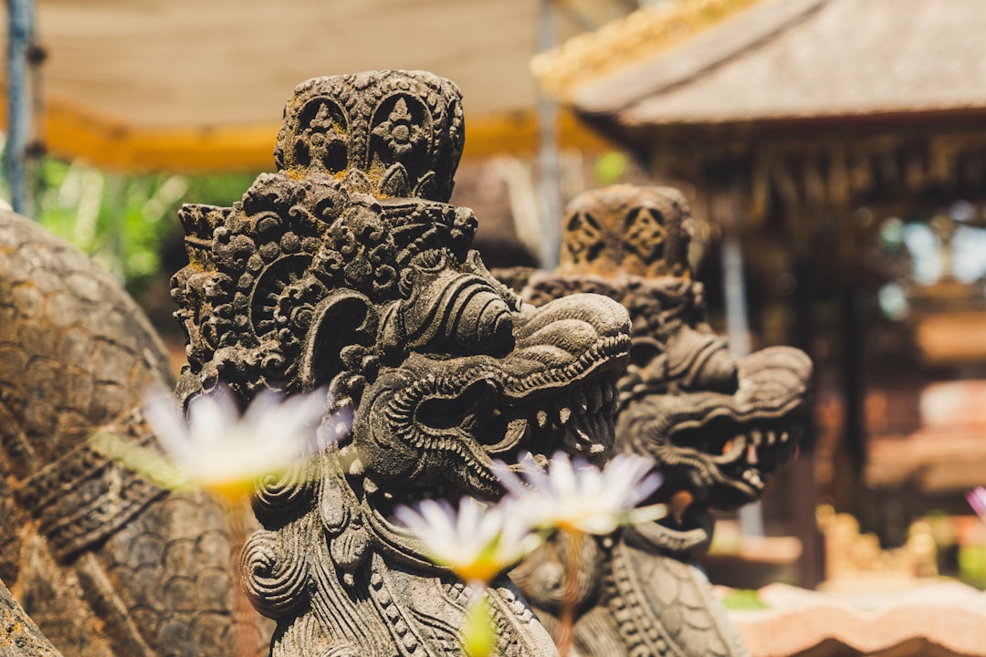 two gray concrete dragon statues outdoor at daytime, A statue in a temple in Bali