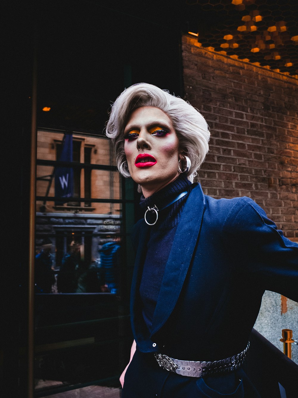 woman wearing blue coat in front of concrete building