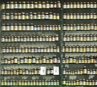 Natural supplements in small glass jars, labeled and arranged on a shelf.