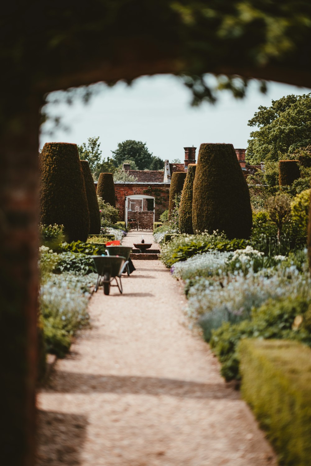 brown walkway beside green grass garden