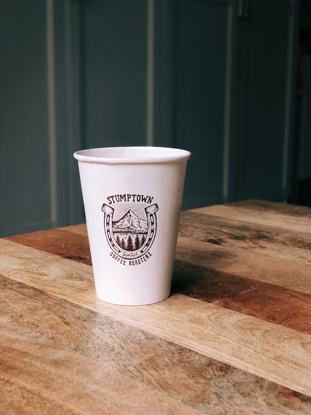 a white cup sitting on top of a wooden table