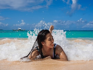 A joyful traveler standing on a pristine beach with turquoise waves gently lapping the shore.