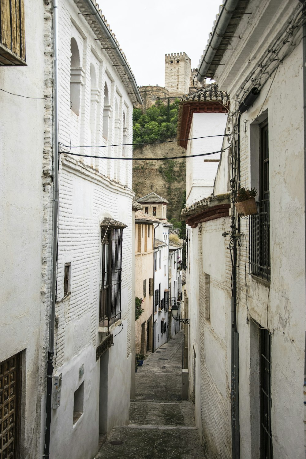 black cables connecting buildings near hill