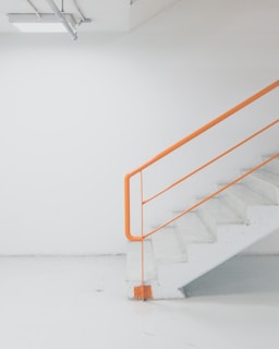 orange metal railing white concrete stairs