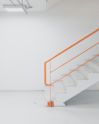 orange metal railing white concrete stairs