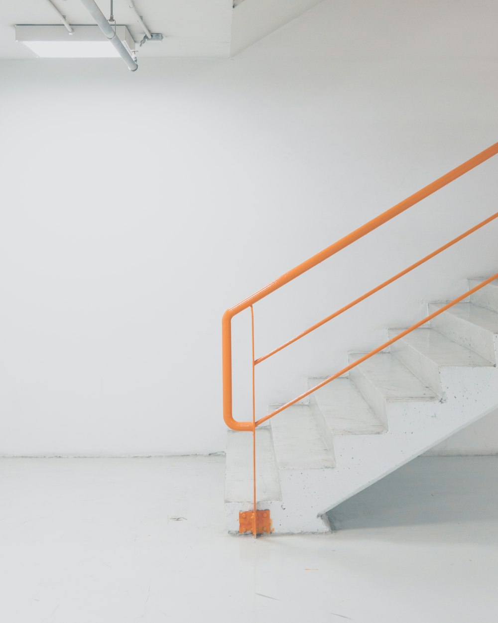 orange metal railing white concrete stairs
