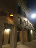 Elegant stone facade of the villa with warm evening lights glowing.
