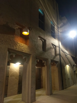 Evening exterior of a residential building showcasing warm lighting and textured facade materials.