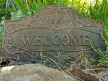 A welcome sign at the entrance of a friendly 55+ community neighborhood.