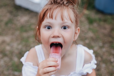 girl licking jar selective focus photography taste teams background