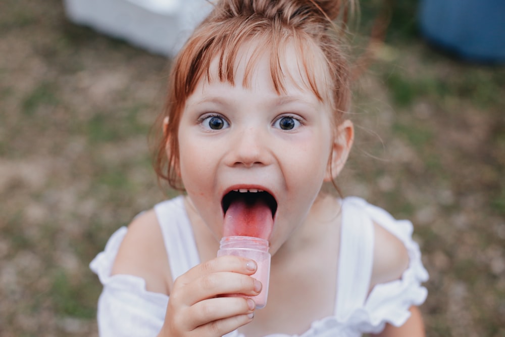 girl licking jar selective focus photography