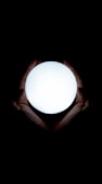Close-up of hands holding a glowing light orb symbolizing inner energy and calm.